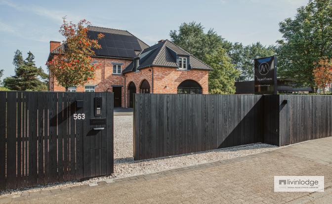 Moderne houten schuifpoort en omheining met zwarte afwerking