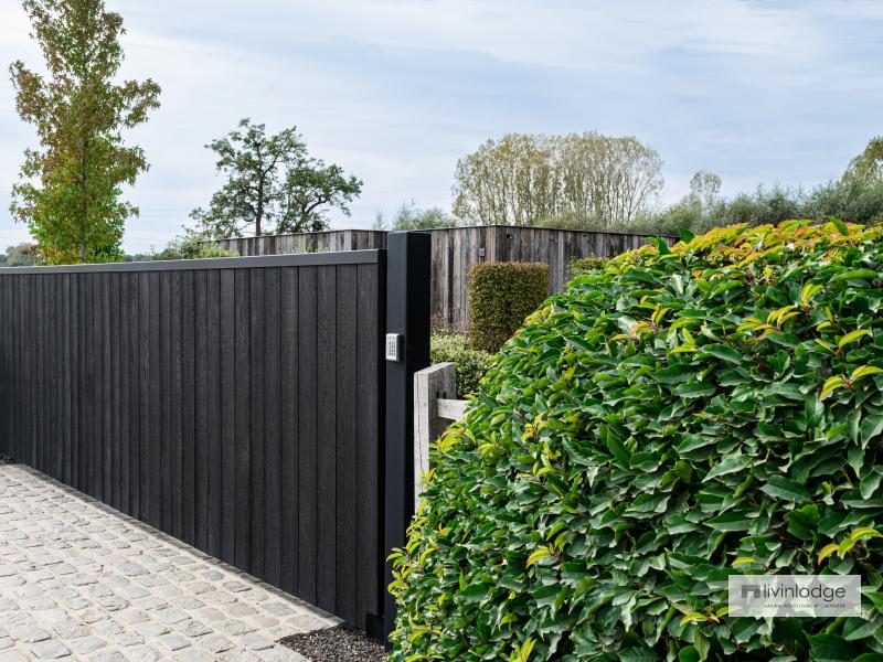 Mooie harmonie tussen zwarte poort en groene omgeving