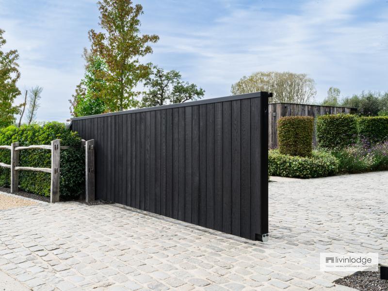 Zwarte houten poort in harmonie met de natuur