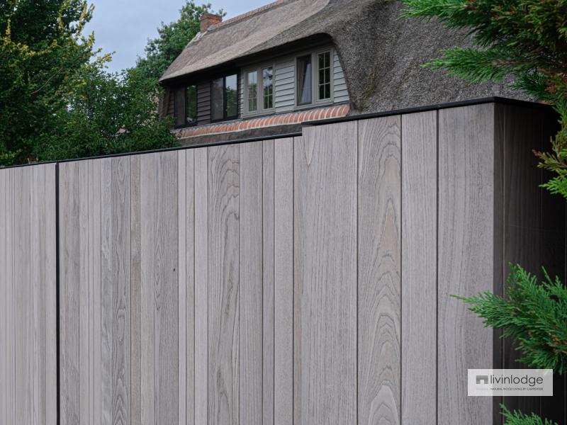 Moderne houten poort bij klassieke woning met rieten dak