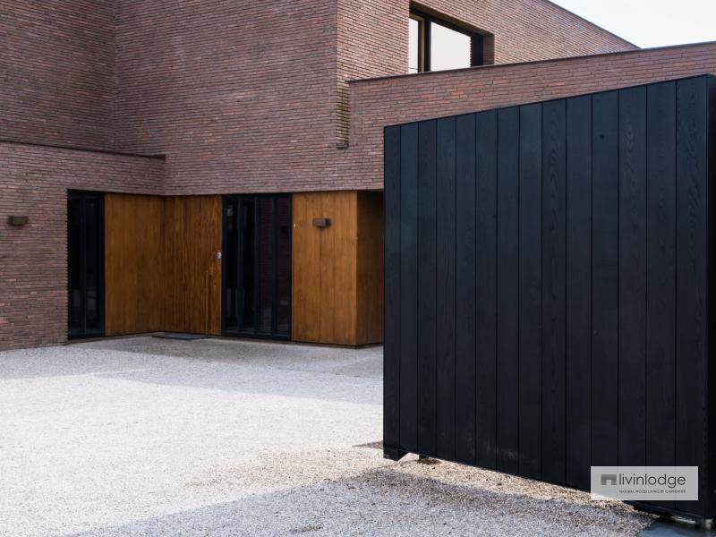 Zwarte houten poort sluit mooi aan bij strakke moderne villa